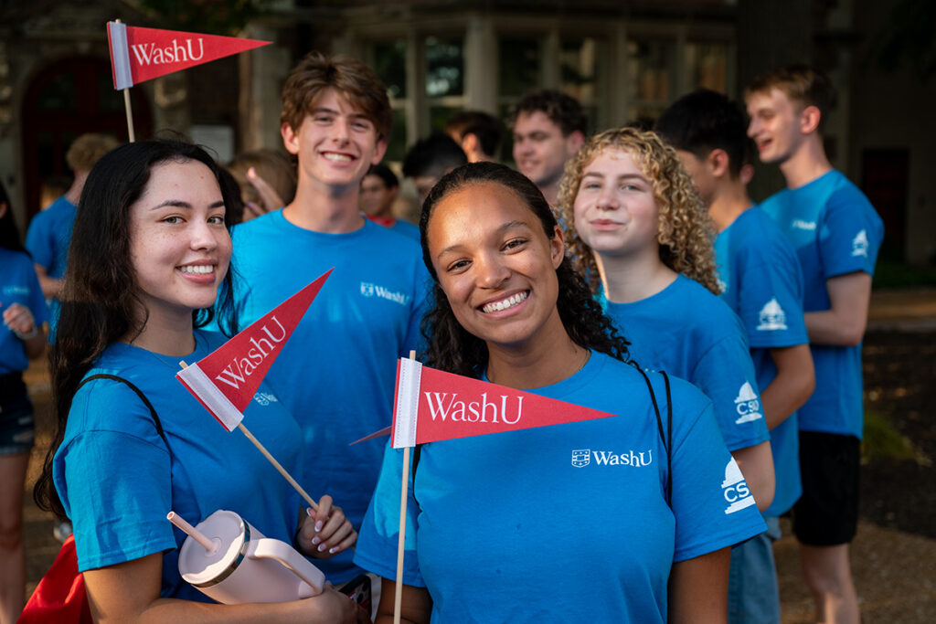 students at convocation holding WashU flags