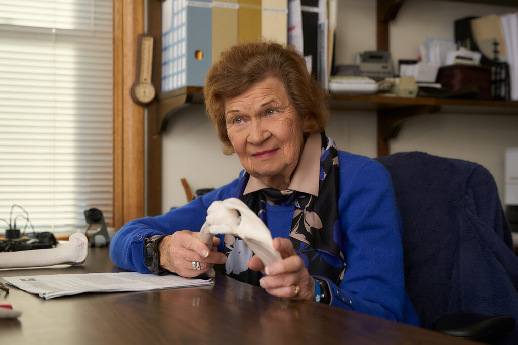 Shirley Sahrmann explaining PT while holding a replica bone
