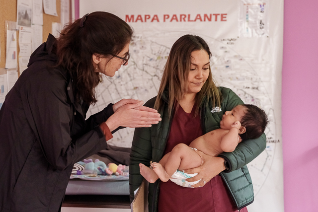 WashU researcher Lora Iannotti talking to a nurse holding a baby